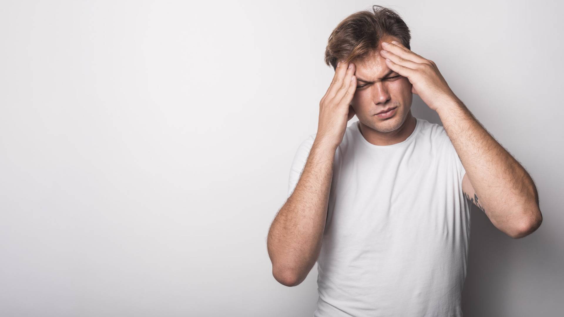 close up young man suffering from headache isolated white background scaled